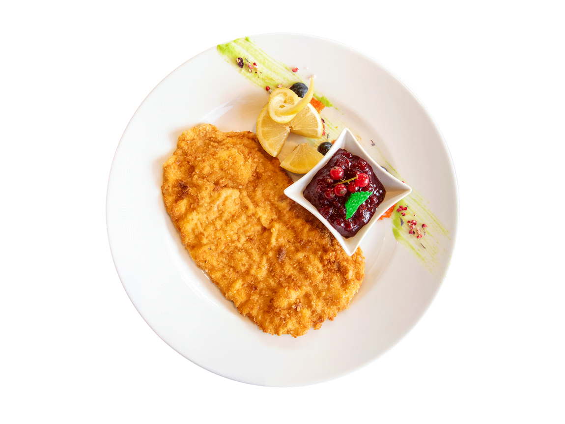 Goldbraune Cotoletta alla milanese, serviert mit Zitrone und Preiselbeerkonfitüre auf einem Gourmet-Teller