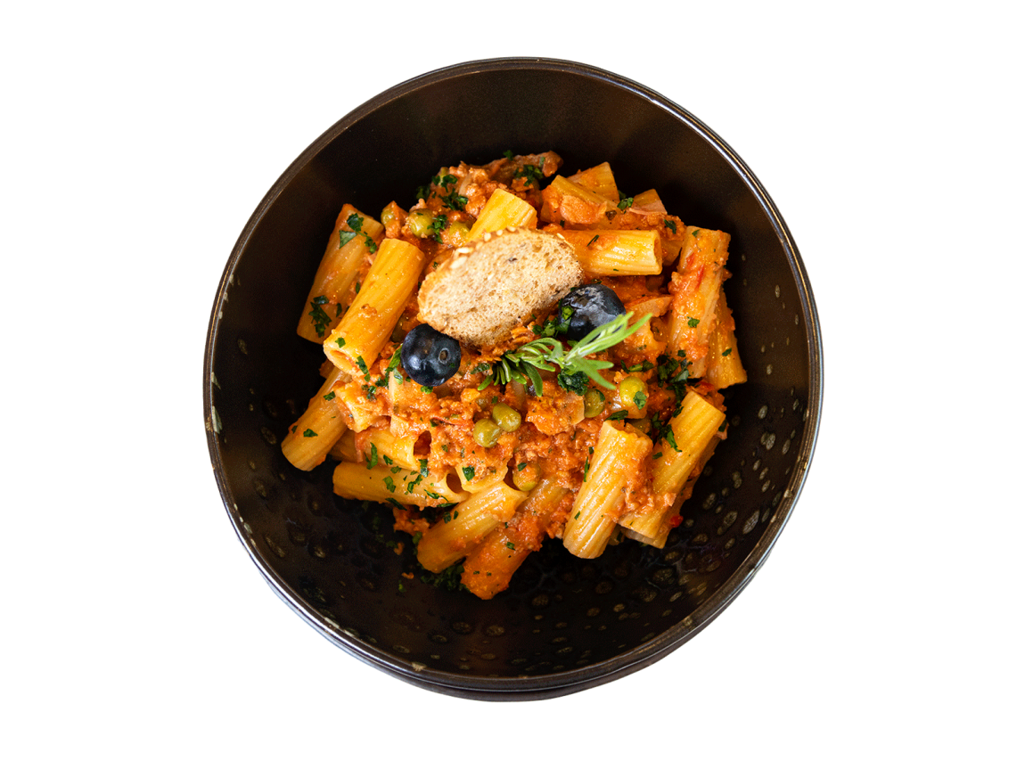Rigatoni-Nudeln mit rustikalem Ragout und Gemüse, serviert in einer Gourmet-Schale mit frischen Kräutern